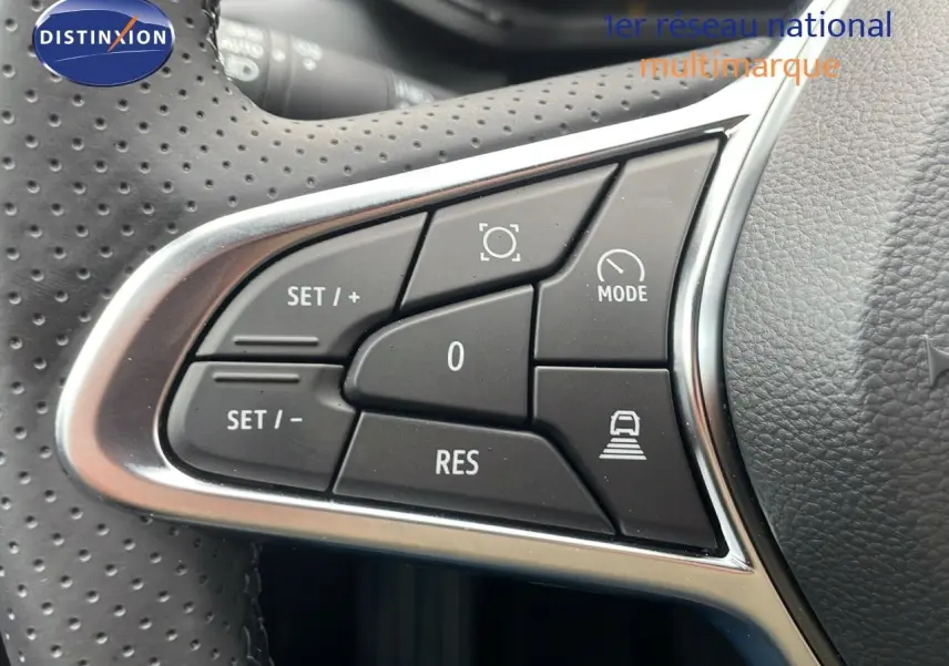 Gros plan sur les commandes de régulateur de vitesse au volant perforé du Renault Captur noir étoile métal 2025.