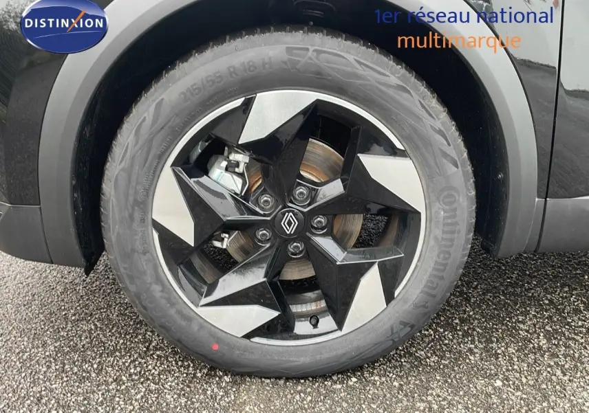 Gros plan sur la roue avant gauche du Renault Captur noir étoile métal avec jante biton au design géométrique.