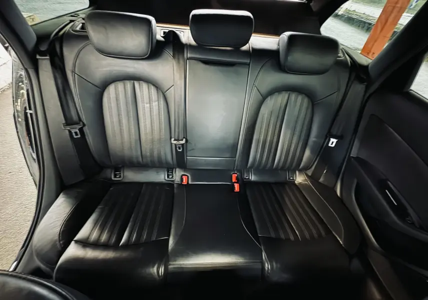 Vue intérieure arrière montrant les sièges en cuir noir de l'Audi A6 Avant Allroad 2016, avec appuie-têtes et ceintures visibles.