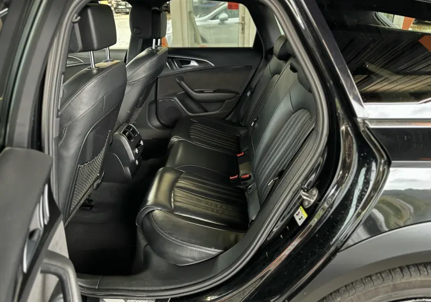 Vue côté droit de l'habitacle arrière noir en cuir de l'Audi A6 Avant Allroad 2016 avec porte ouverte.