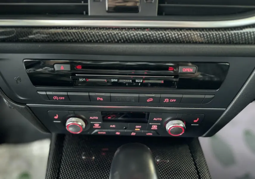 Gros plan sur la console centrale noire de l'Audi A6 Avant Allroad 2016, avec commandes climatisation et bouton de démarrage.