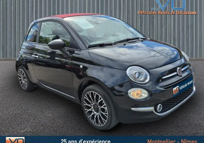 Fiat 500C noire 2024 vue 3/4 avant droit avec toit rouge et jantes alliage, équipée d'une roue de secours visible