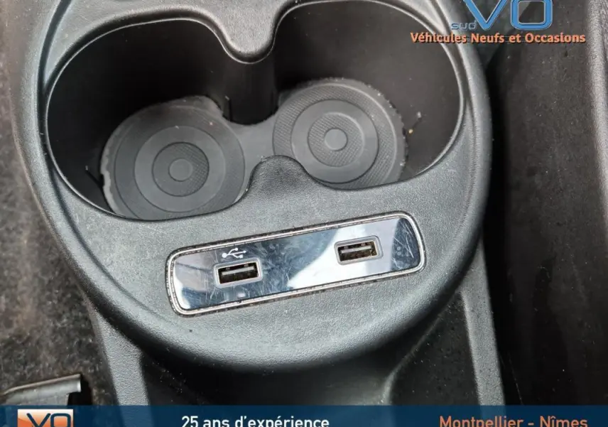 Prise USB double et porte-gobelets noirs dans l'habitacle du Fiat 500C 2024 côté console centrale.