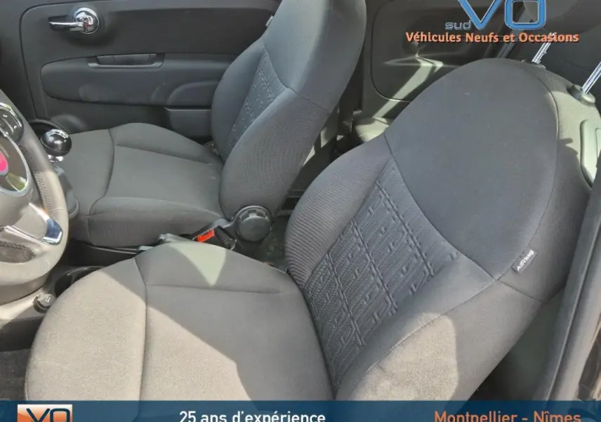 Intérieur de la FIAT 500C 2024 noir, vue côté gauche sur les sièges avant en tissu avec levier de vitesses manuel.