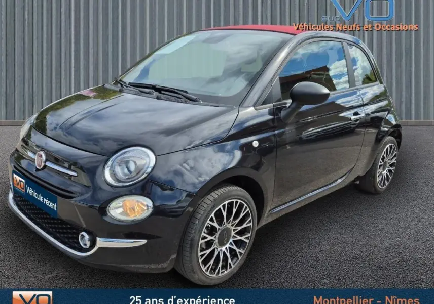 Vue 3/4 avant droite d'une FIAT 500C noire 2024 avec toit rouge et jantes alliage multibranches élégantes.