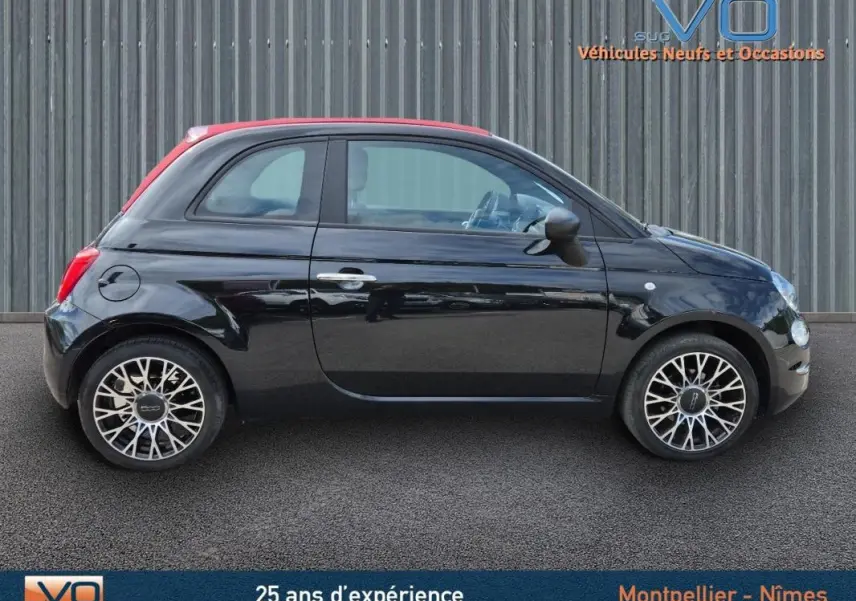 Profil côté gauche d'une FIAT 500C noire 2024 avec toit rouge et roues alliage au design complexe.