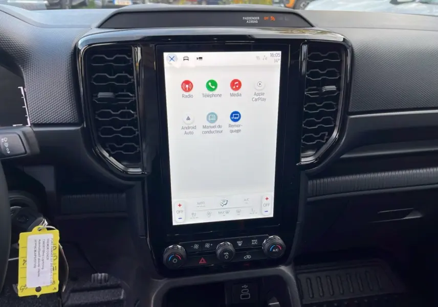Vue intérieure centrée sur l'écran tactile vertical du Ford Ranger 2025 avec commandes climatisation et tableau de bord noir.