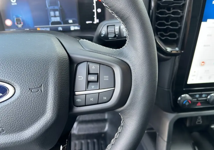 Gros plan sur le volant cuir multifonctions et l'écran tactile du tableau de bord du Ford Ranger 2025.