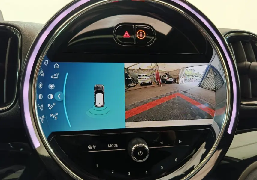 Écran tactile rond affichant la caméra de recul et capteurs de stationnement dans un MINI Countryman blanc 2021.