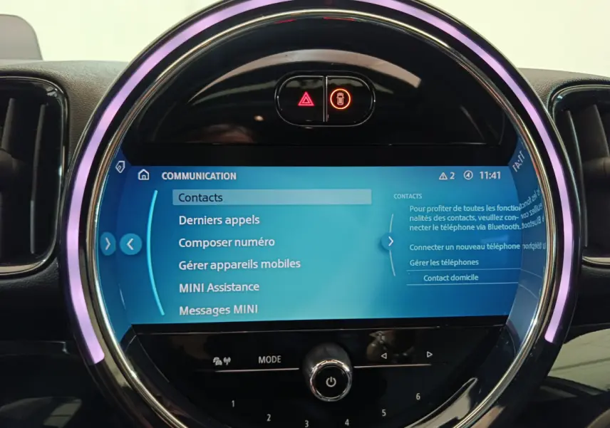 Écran tactile central circulaire du tableau de bord MINI Countryman blanc, avec interface Bluetooth et commandes lumineuses.
