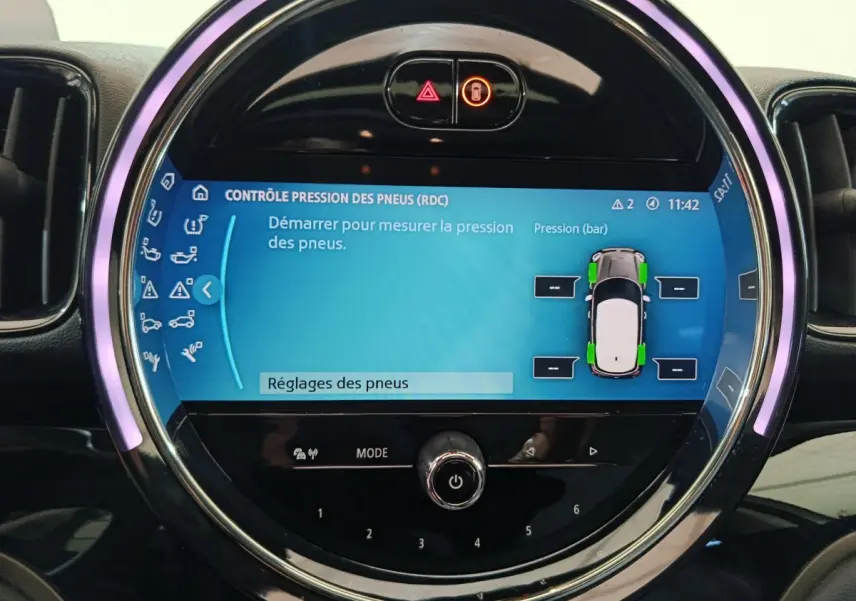 Écran tactile circulaire du tableau de bord du MINI Countryman blanc, affichant le contrôle pression des pneus.