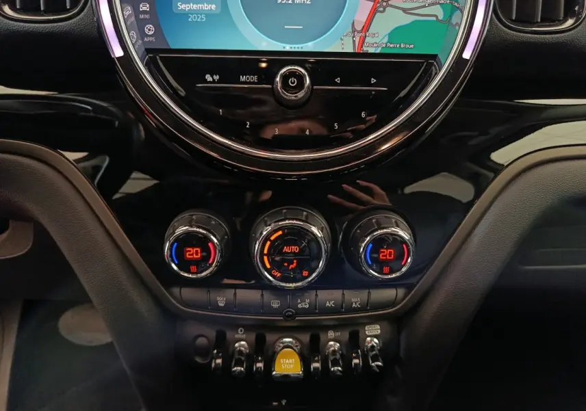 Gros plan sur la console centrale du MINI Countryman blanc 2021, avec commandes climatisation et écran tactile rond.