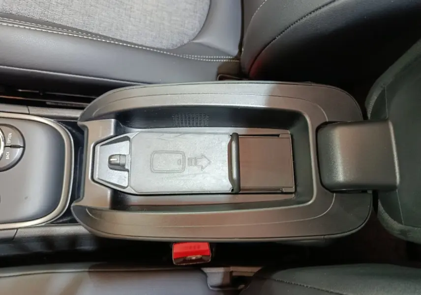 Vue rapprochée de la console centrale noire du MINI COUNTRYMAN hybride avec rangement et molette de commande.