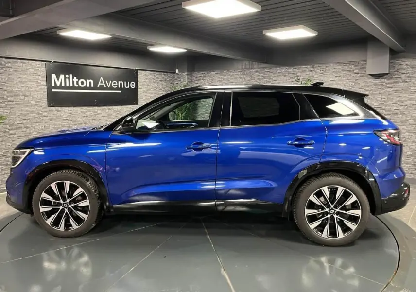 Profil côté gauche du Renault Austral 2023 bleu Iron avec toit noir étoilé et jantes alliage noires diamantées.
