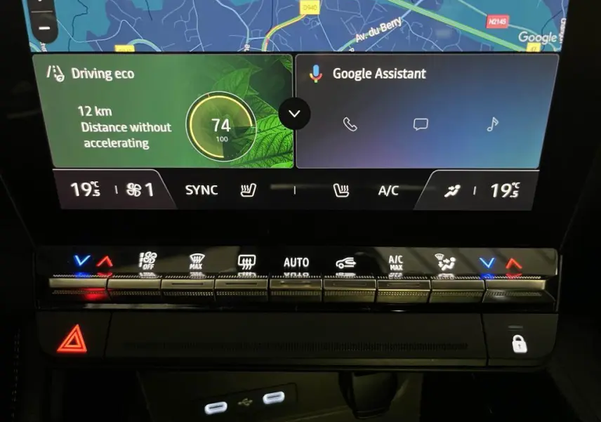 Gros plan sur la console centrale tactile du Renault Austral bleu, affichant la navigation et commandes climatisation.