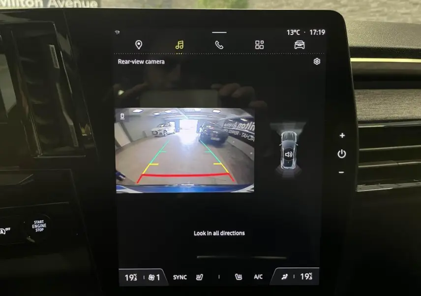 Écran central affichant la caméra de recul du Renault Austral bleu, vue arrière en intérieur de garage.