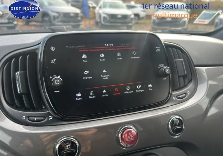 Écran tactile central et commandes du tableau de bord gris d'une Fiat 500 1.0 70 bsg cult vue de face rapprochée.