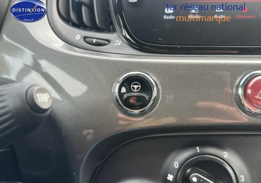 Gros plan sur la console centrale grise de la FIAT 500 1.0 70 bsg cult avec bouton de réglage du volant et commandes climatiques.