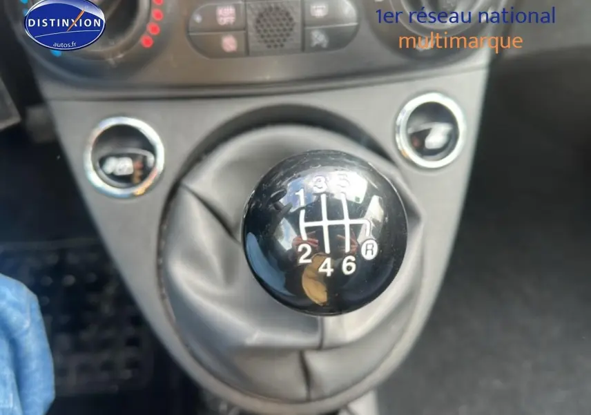 Gros plan sur le levier de vitesses manuel noir de la FIAT 500 gris, avec indication des six rapports visibles.