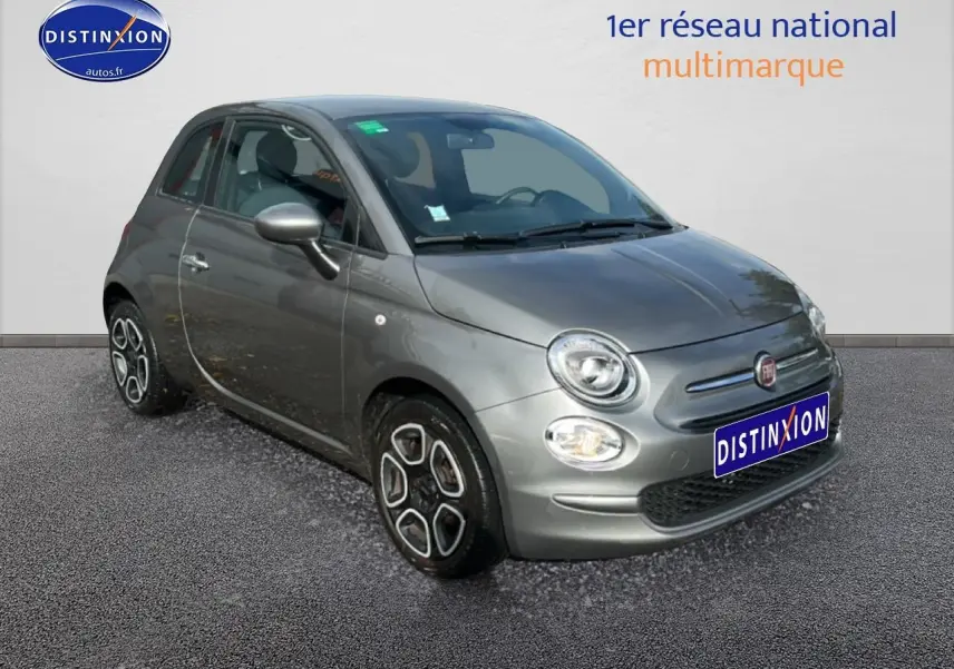 Fiat 500 gris vue 3/4 avant droit avec jantes originales et phares ronds allumés sur fond neutre.