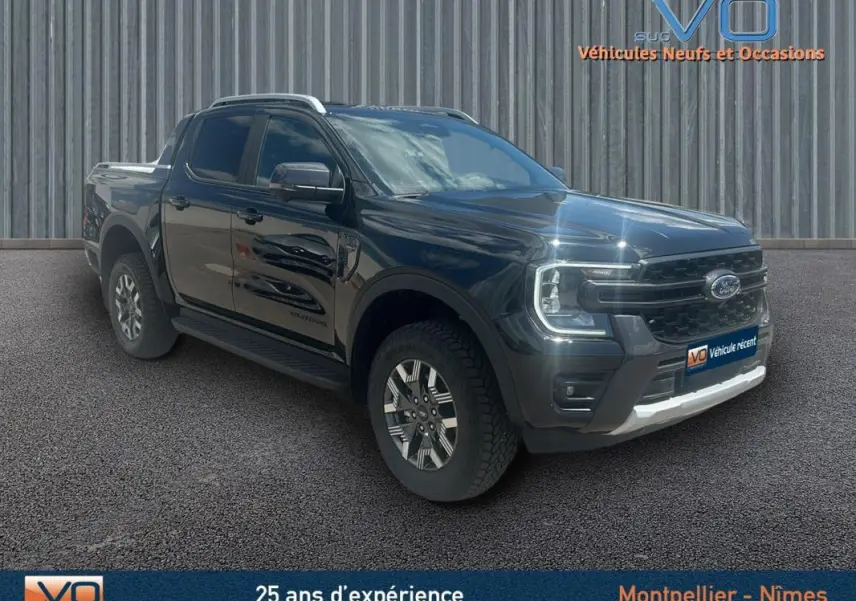 Ford Ranger Wildtrak noir en 3/4 avant droit avec barres de toit, marchepieds et jantes alliage 18 pouces.