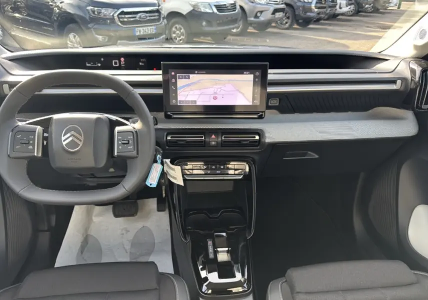 Vue intérieure avant du Citroën C3 Aircross hybride 2025 avec tableau de bord moderne et écran tactile central.