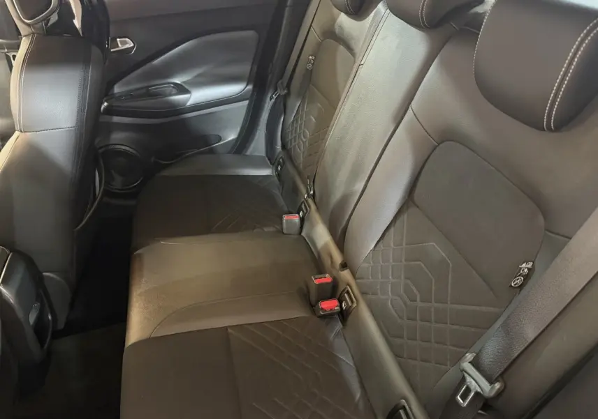 Vue intérieure sur la banquette arrière noire du Nissan Juke 2021, avec détails de coutures et ceintures visibles.