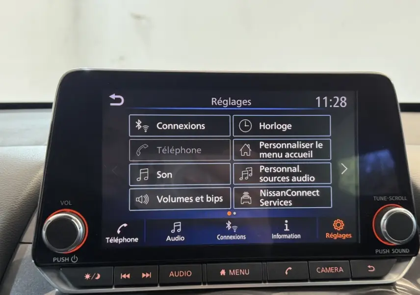 Écran tactile central du tableau de bord du Nissan Juke gris clair, affichant le menu Réglages à 11h28.