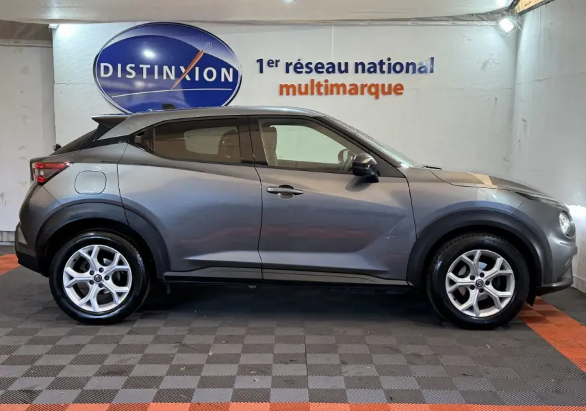 Profil côté gauche du Nissan Juke gris clair 2021, soulignant ses lignes compactes et ses jantes alliage.