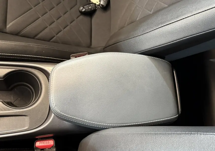 Accoudoir central en cuir gris avec surpiqûres blanches et porte-gobelet dans Nissan Juke Tekna 2021.