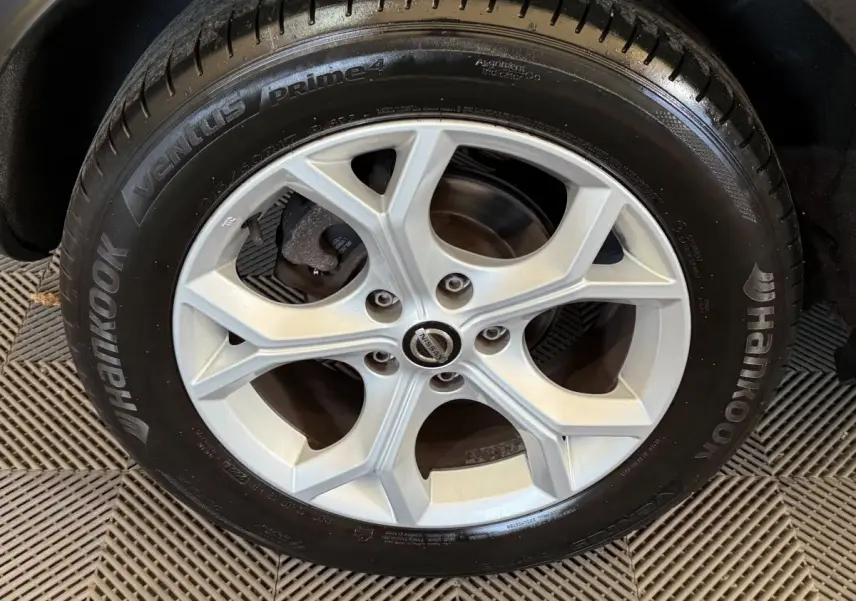 Vue rapprochée sur la roue arrière droite du Nissan Juke gris clair, mettant en valeur le pneu Hankook et la jante.