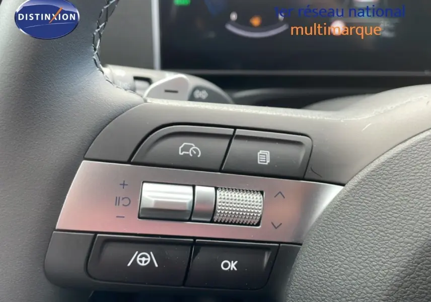 Gros plan sur les commandes multifonctions à gauche du volant du Hyundai Tucson blanc Atlas, version hybride 2026.