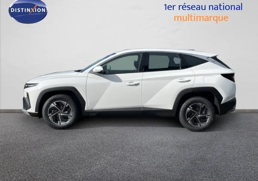 Profil droit du Hyundai Tucson 1.6 TGDI HEV 239ch blanc Atlas avec jantes alliage et détails noirs contrastants.