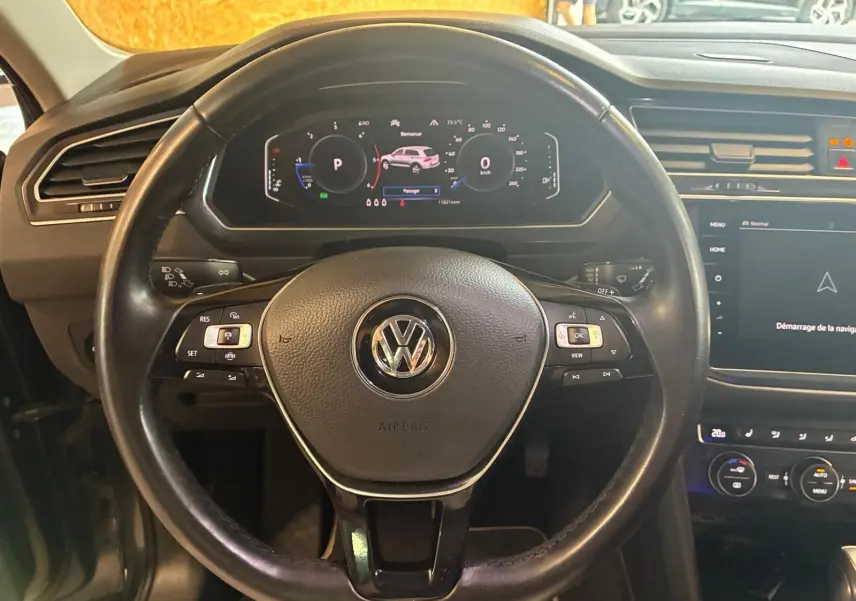 Vue rapprochée du volant noir de Volkswagen Tiguan 2020 avec tableau de bord numérique et écran tactile central.