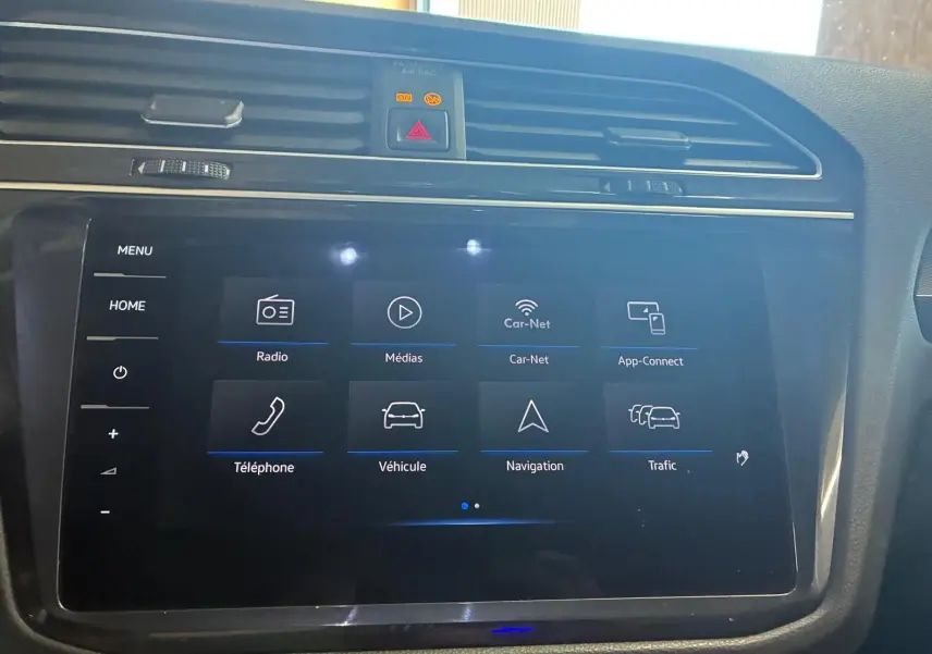 Écran tactile central du tableau de bord du Volkswagen Tiguan gris, affichant le menu multimédia et navigation.