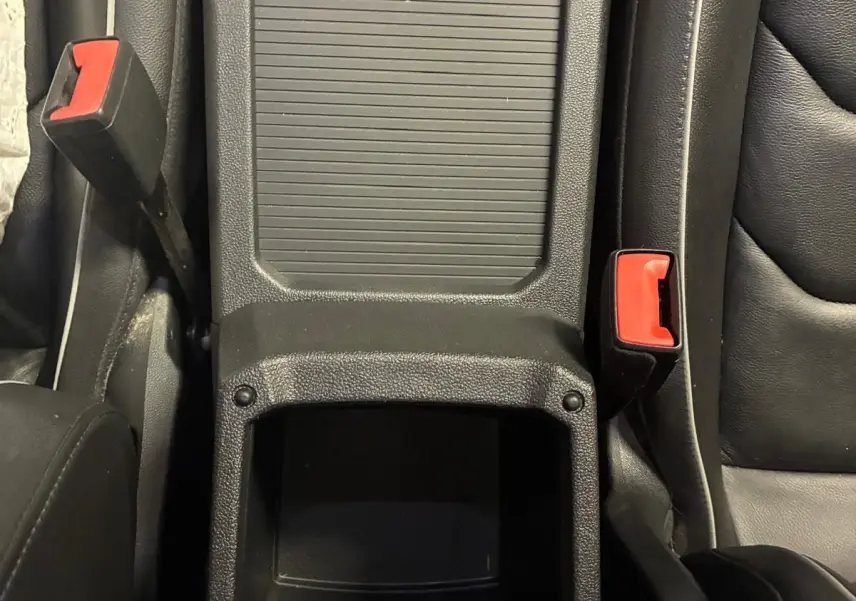 Vue plongeante sur la console centrale noire en cuir du Volkswagen Tiguan 2.0 TDI avec boutons et espace de rangement.