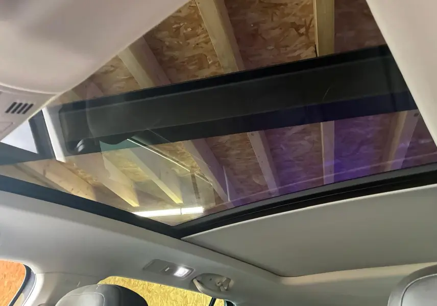 Toit panoramique ouvert vu de l'intérieur sur un Volkswagen Tiguan gris, montrant la partie supérieure et les sièges avant.