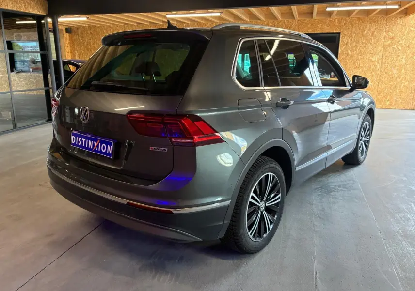 Vue 3/4 arrière droite d'un Volkswagen Tiguan gris 2.0 TDI 190 4MOTION, avec jantes alliage et badge 4MOTION visible.