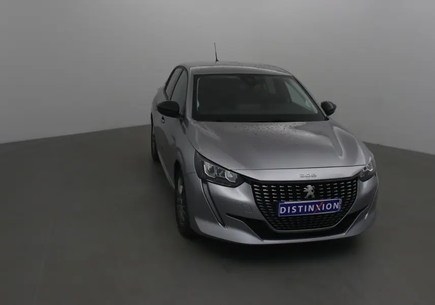 Peugeot 208 1.2 PureTech 100 Style gris Artense vue 3/4 avant avec calandre distinctive et pluie sur la carrosserie.