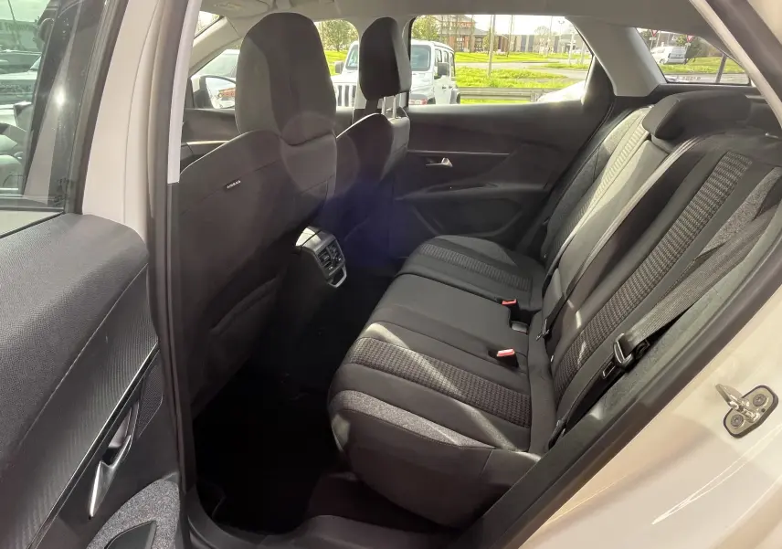 Vue intérieure côté droit des sièges arrière noirs du Peugeot 3008 blanc, avec ceintures et aérateurs centraux visibles.