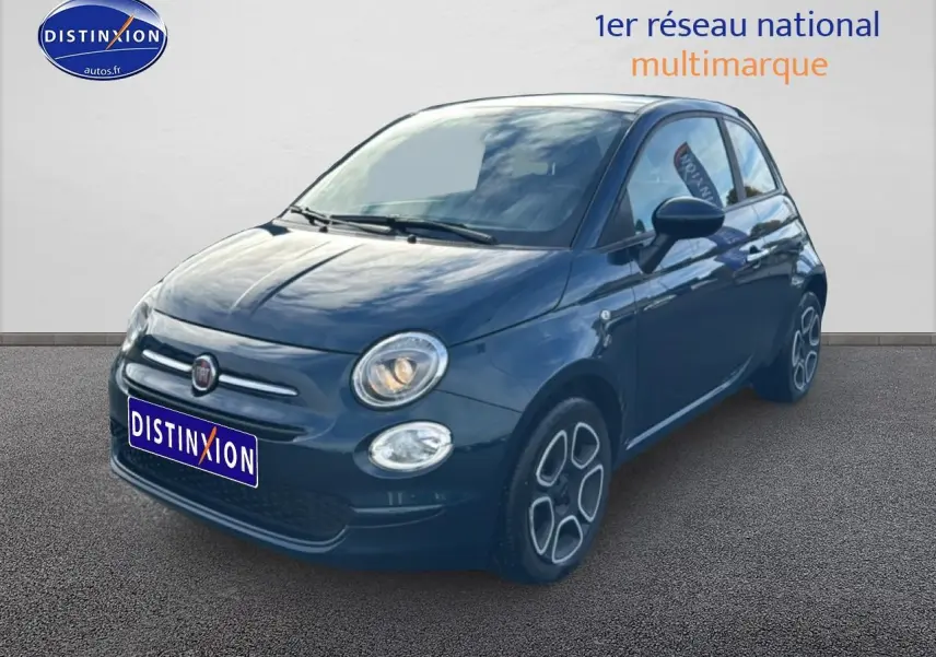 Vue 3/4 avant droite d'une FIAT 500 bleu foncé avec phares allumés sur fond neutre.