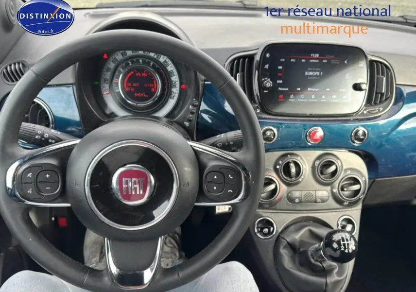 Vue intérieure centrée sur le volant cuir et tableau de bord bleu foncé de la Fiat 500 1.0 70 bsg cult 2023.