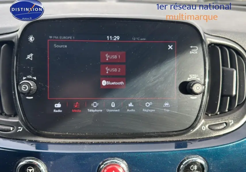 Écran tactile central de la Fiat 500 bleu foncé, vue rapprochée du tableau de bord avec commandes multimédia.
