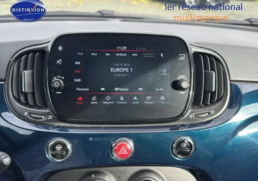Vue rapprochée du tableau de bord bleu foncé de la Fiat 500 2023 avec écran tactile et commandes centrales.