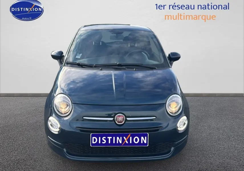 Vue frontale d'une FIAT 500 1.0 70 bsg cult bleu foncé avec phares allumés sur fond neutre.