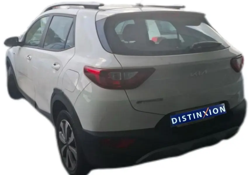 Vue 3/4 arrière gauche d'un KIA Stonic blanc 2022 avec toit noir et jantes alliage distinctives.