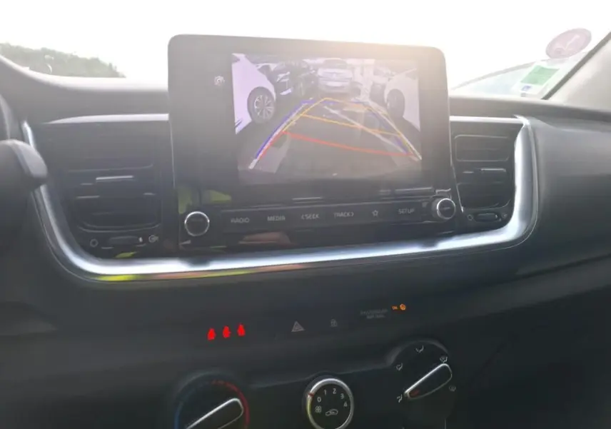 Vue intérieure du tableau de bord du KIA STONIC 2022, écran central affichant la caméra de recul avec aides au stationnement.