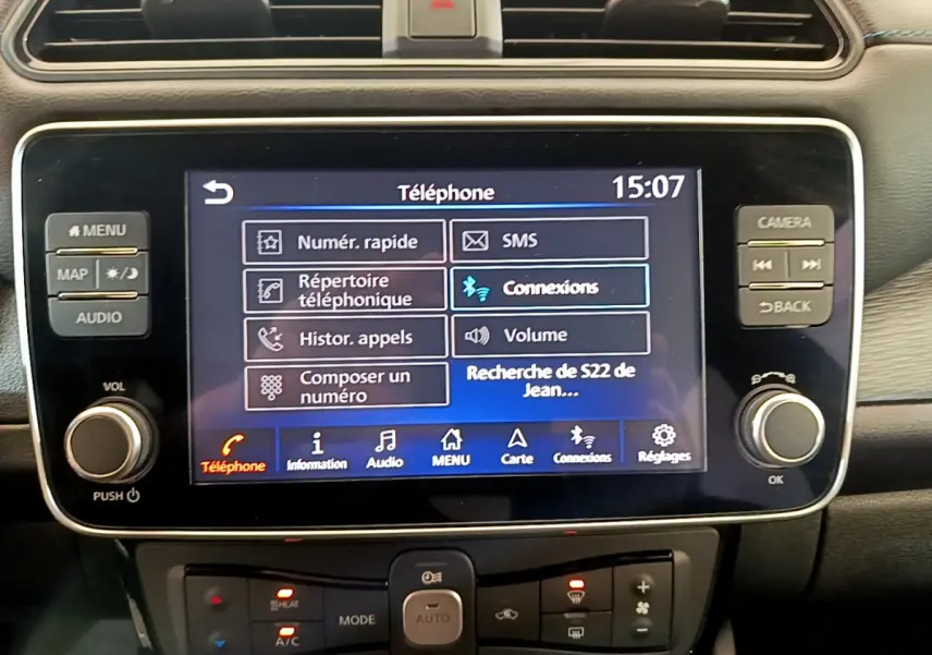 Écran tactile central du tableau de bord noir de la Nissan Leaf blanche, affichant le menu téléphone à 15h07.