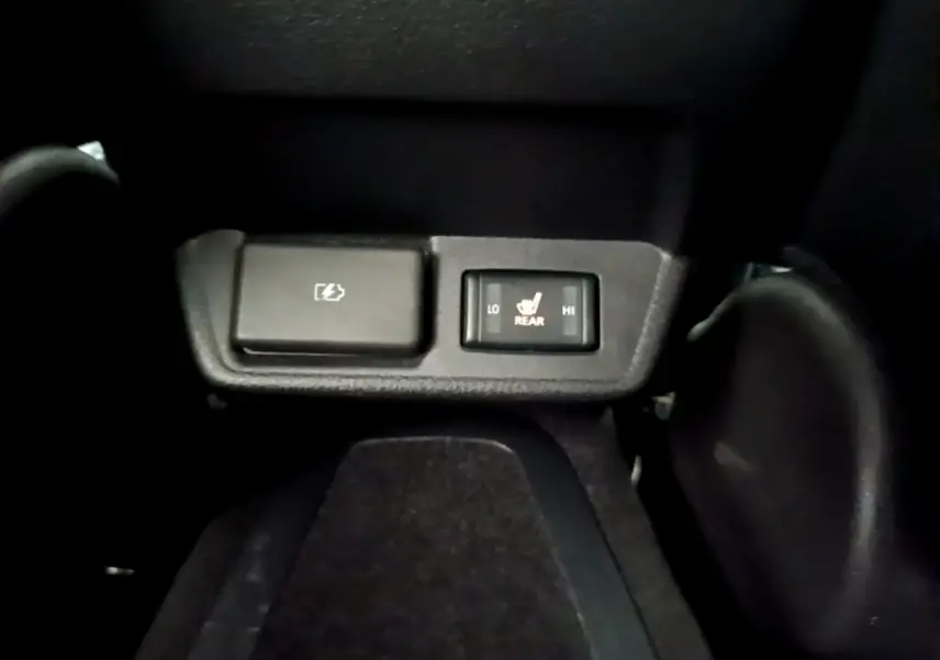 Gros plan sur les commandes noires de chauffage des sièges arrière dans une Nissan Leaf blanche de 2020.