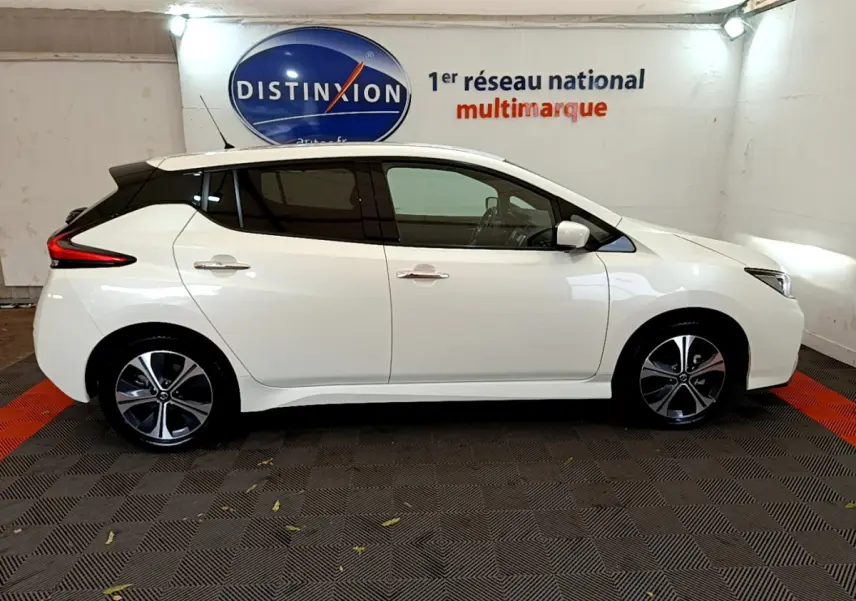 Profil latéral droit d'une Nissan Leaf blanche 2020 électrique, avec jantes alliage et vitres teintées.
